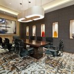 Image is of a chic office conference room with a flat screen TV monitor on the wall.